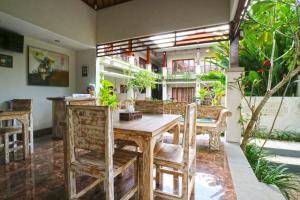 - une salle à manger avec une table et des chaises en bois dans l'établissement Avisara Villa & Suite, à Nusa Dua