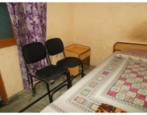 a room with two chairs and a table and a bed at Deluxe Stay near ISBT in Rishīkesh