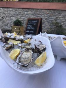 a plate of oysters and lemon slices on a table at Castelnovo Resort in Castelnovo neʼ Monti
