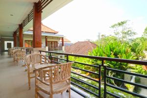 a balcony of a house with chairs and tables at Avisara Villa & Suite in Nusa Dua