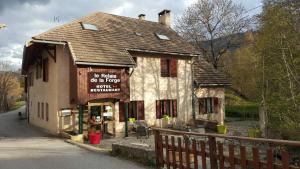 un bâtiment avec un panneau sur son côté dans l'établissement Le Relais de la Forge, à Selonnet