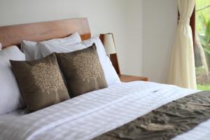 a bedroom with a bed with pillows and a window at Private Pool Villa - Villa Saia Ubud in Ubud +38 photos