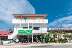 un bâtiment avec un panneau vert devant lui dans l'établissement Sweet Cenang Memories Inn, à Pantai Cenang