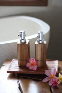 a bathroom with two faucets and a sink and flowers at Private Pool Villa - Villa Saia Ubud in Ubud