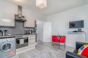 a kitchen and living room with a table and a couch at The Rock Apartments in Plumstead