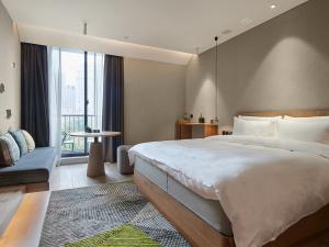 um quarto com uma cama grande e uma janela grande em EBO Hotel Hangzhou Wulin em Hangzhou