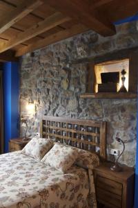 CaleaoにあるLa Prida Apartamentos Ruralesの石壁のベッドルーム1室(ベッド1台付)