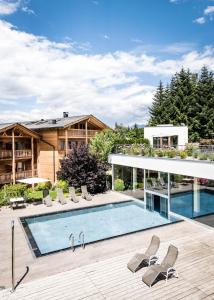 einen Pool mit Stühlen und ein Haus in der Unterkunft Hotel Gasserhof in Brixen