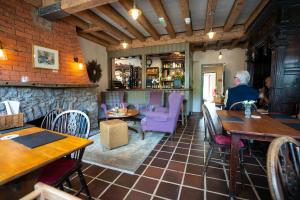 a person sitting at a table in a restaurant at West Arms Hotel in Llanarmon Dyffryn-Ceiriog