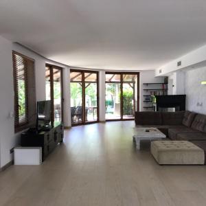 salon z kanapą i telewizorem w obiekcie Villa with Heated Pool and Jacuzzi close to Puerto Banus and Beach w mieście Estepona