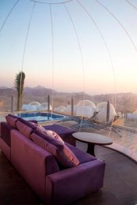 a living room with a purple couch and a pool at Petra Bubble Luxotel in Wadi Musa
