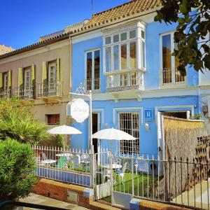 una casa azul con dos sombrillas delante en La Casa Azul B&B + Apartments, en Málaga