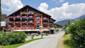 a large building with flowers on the balconies on a road at Hotel Hocheder in Seefeld in Tirol