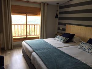 1 dormitorio con 2 camas y balcón en Hotel Supermolina, en La Molina
