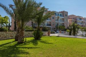 a yard with two palm trees in front of a building at Elysia Park in Paphos