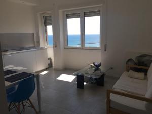 a living room with a table and two windows at B&blu in Santa Marinella