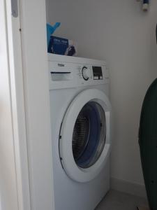 eine weiße Waschmaschine in einer Ecke eines Zimmers in der Unterkunft B&blu in Santa Marinella