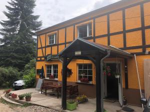 an orange building with a table and chairs in front of it at Riverside Inn in Oderberg