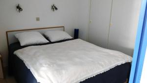 ein Bett mit zwei weißen Kissen darüber in der Unterkunft Figure de proue, Les Sables d Olonne, port Bourgenay, Talmont saint Hilaire in Talmont