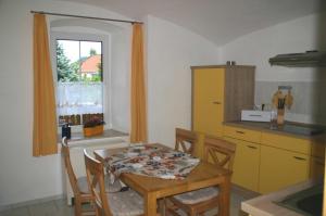 a kitchen with a table and chairs and a window at Ferienhof An der Weide in Kurort Gohrisch