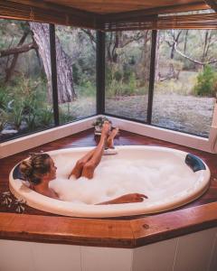 Eine Frau in einer Badewanne mit einem Baby darin. in der Unterkunft William Bay Cottages in Denmark