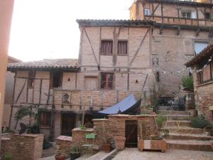 ein altes Steinhaus mit einem Zelt davor in der Unterkunft La lauze et l'anguille in Gaillac