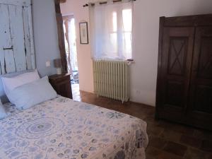 a bedroom with a bed and a window at La lauze et l'anguille in Gaillac