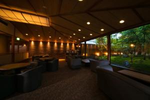 un restaurant avec des canapés et des tables et une grande fenêtre dans l'établissement Yakakutei, à Kirishima