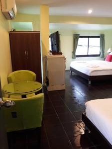 a hotel room with a bed and a table and chairs at Kluay Mai Guest House in Chaweng