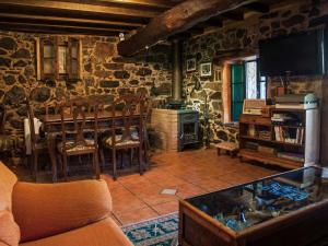 a living room with a table and a stone wall at Paraíso Ortegal in Feás