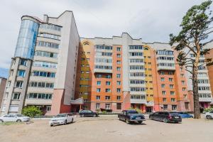 a group of buildings with cars parked in a parking lot at Dekabrist Apartment Shilova 46 in Chita