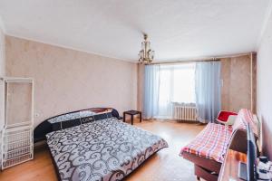 a bedroom with a bed and a window at Dekabrist Apartment Shilova 46 in Chita