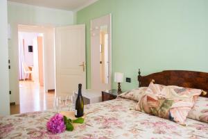 QueroにあるLocanda Solagnaのベッドルーム1室(ワイン1本、ワイングラス付)