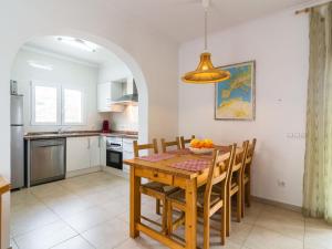 uma cozinha e sala de jantar com uma mesa de madeira e cadeiras em Belvilla by OYO Casa Monta a de Alegria em Pedreguer