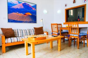 カレタ・デ・ファマラにあるSeaview Risco de Famara 2のリビングルーム(ソファ、テーブル、椅子付)