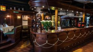 a bar in a restaurant with a vase of flowers at Hotel Holland House Old Town in Gdańsk