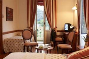 ピエルフィット・ネスタラにあるGrand Hôtel de Franceのベッド、テーブル、椅子が備わるホテルルームです。