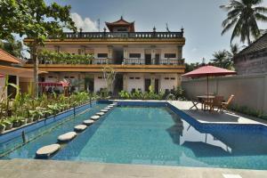 a swimming pool in front of a building with a house at Saka Boutique Hotel in Nusa Penida