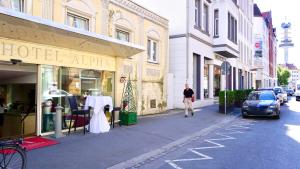 un hombre caminando por una calle frente a una tienda en Hotel Alpha en Hannover