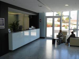 a lobby with two people sitting in chairs in a building at Ágora Spa & Resort in Peñíscola +65 photos