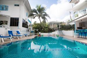 a swimming pool with blue chairs and a building at Baan Suan Villa 1 in Patong Beach