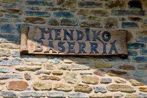 una señal en el costado de una pared de ladrillo en Mendiko Baserria en Amurrio