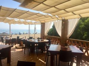 un restaurante con mesas y sillas y vistas a la playa en Playa Real, en Marbella