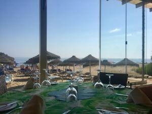 una mesa en una playa con sillas y sombrillas en Playa Real, en Marbella