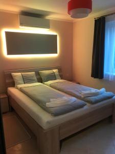 1 dormitorio con 1 cama con luz encendida en Gold de luxe Apartman, en Hajdúszoboszló