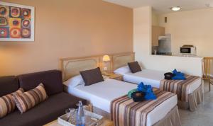 a hotel room with two beds and a couch at Marola Park in Playa de las Americas