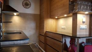 eine Küche mit einem Waschbecken und einer Uhr an der Wand in der Unterkunft Erlebnis - Hütten Falkert by S4Y in Patergassen