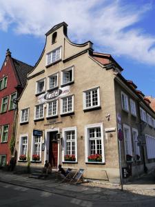 a building with people sitting in chairs in front of it at La Guitarra Hostel Gdańsk in Gdańsk