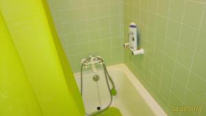 um chuveiro numa casa de banho com uma parede verde em Sunny flat In Machico city em Machico