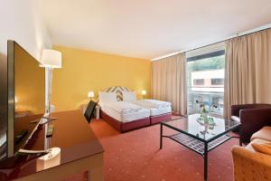 ザルツブルクにあるホテル ノイトール エクスプレスのベッドとテーブルが備わるホテルルームです。